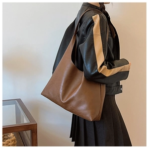 Brown large-capacity faux leather tote bag shown on model for size and style reference