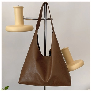 Detail of dark brown tote bag with textured PU leather hanging on a silver metal stand
