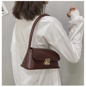 Détail du sac à bandoulière en cuir rouge vin avec fermoir métallique doré