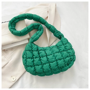 Close-up of vibrant green quilted puff bag with textured square pattern on nylon fabric