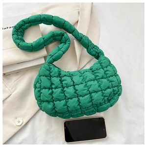 Detail of green quilted bubble shoulder bag on a white suit with trendy cloud texture