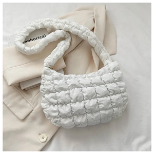 Detail of white quilted cloud bag featuring soft puffy texture and mini handle design