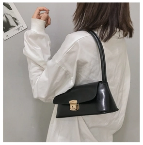 Détail du sac baguette en cuir noir doté d'un fermoir à boucle en métal doré chic