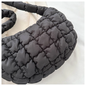 Macro detail of black quilted bubble bag showing high-quality nylon texture and grid pattern