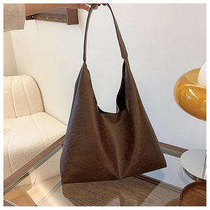 Close-up of brown tote bag featuring retro leather texture and elegant slouchy design