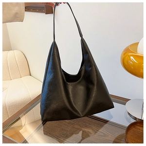 Detail of a minimalist black PU leather tote bag with smooth curved opening and chic texture