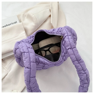 Detail of purple quilted cloud bag interior showing capacity with glasses and wallet