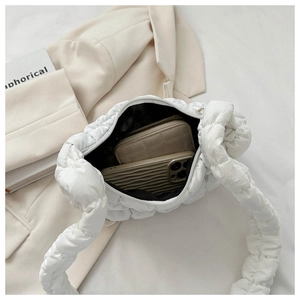 Detailed interior of a white quilted bubble bag with smooth zipper and black lining