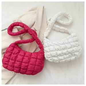 Detail of quilted bubble shoulder bags in magenta and white with padded square patterns