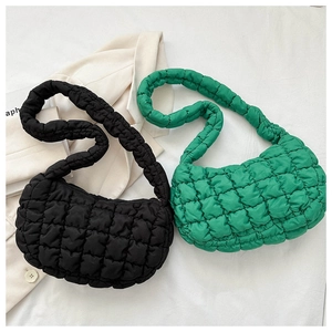 Detail of puffed quilted texture on black and green cloud bags with sleek zipper closure