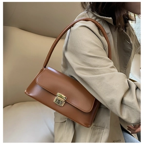 Gros plan sur le sac baguette marron vintage avec un fermoir en métal doré de forme carrée