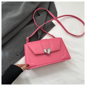 Close-up of pink PU leather crossbody bag featuring a silver heart-shaped metal buckle