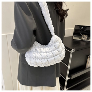 Detail of white quilted bubble cloud bag showing texture on woman shoulder