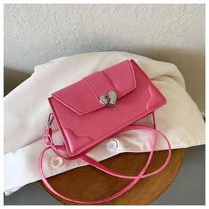 Detailed view of pink shiny leather handbag with silver heart-shaped metallic lock