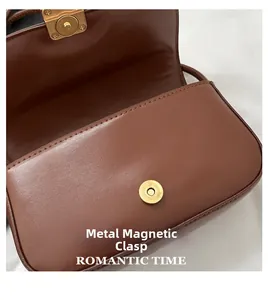 Detail view of dark brown shoulder bag featuring metal magnetic buckle closure and internal compartment
