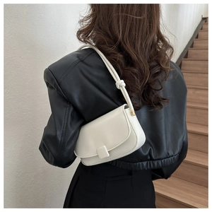Detail of cream white leather handbag with flap closure and stylish knot shoulder strap