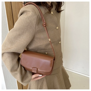 Brown leather shoulder bag with a rectangular flap and a unique knotted strap detail