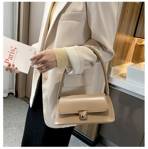 Détail d'un sac à main vintage en cuir abricot avec un fermoir rotatif en métal doré chic