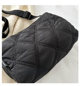Detail of black quilted nylon crossbody bag with diamond stitching and adjustable strap