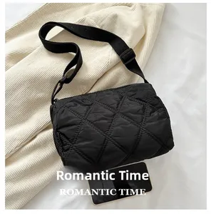 Detailed view of black quilted nylon bag showing compact size compared to a smartphone