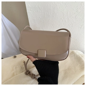 Close-up of khaki leather crossbody bag featuring a square buckle and fine white stitching