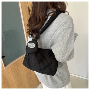 Borsa a tracolla trapuntata nera con mini borsellino rimovibile su una modella