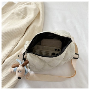 Detail view of nylon quilted bag interior holding two smartphones and cute dog charm