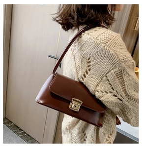 Détail du sac porté épaule vintage marron avec fermoir doré sur un mannequin