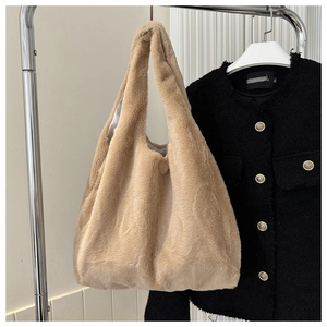 Détail d'un sac cabas en fausse fourrure beige suspendu avec un manteau en laine chic