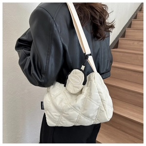 Dettaglio di una borsa a tracolla trapuntata con cinghia larga e mini portamonete rotondo
