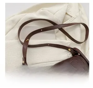 Détail de la bandoulière réglable et broderie sur sac bandoulière vintage marron foncé