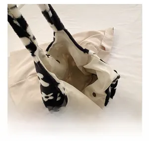 Detail view of the spacious interior with magnetic closure on this plush cow print tote bag
