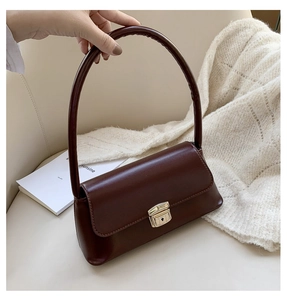 Détail du sac à main en cuir bordeaux avec une boucle carrée en métal doré rétro