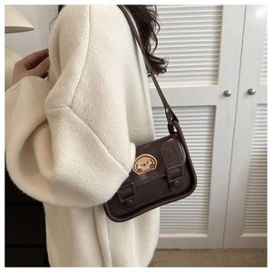 Sac à bandoulière vintage marron avec broderie chiot, porté sur un cardigan en maille beige