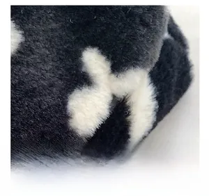 Macro detail of soft faux fur material featuring a black and white star pattern texture
