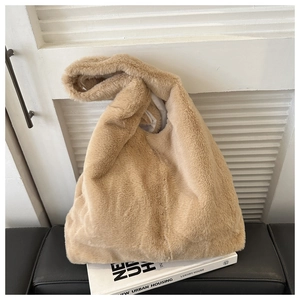 Detail der kamelfarbenen Kunstfell-Tasche mit weicher Textur und geknotetem Griff