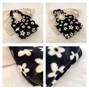 Detail of plush floral tote bag showing black and white flower pattern and soft texture