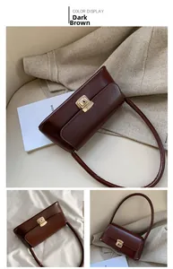 Détail du sac à main vintage marron foncé avec fermoir doré élégant sur une chaise