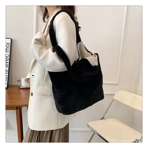 Detail of soft black plush tote bag texture and large capacity shown in a stylish setting