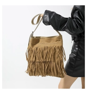 Detail of a khaki suede shoulder bag featuring three-layer fringe and a retro chic design