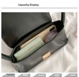 Vue de l'intérieur d'un sac à main noir en PU avec téléphone et cosmétiques