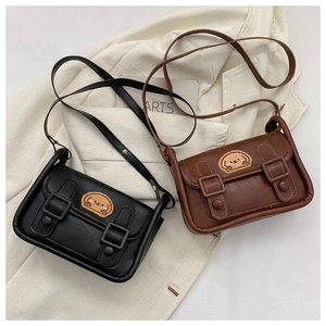 Détail de mini sacs à rabat avec broderie chiot et double boucles sur tissu doux