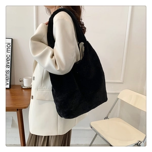 Detail showing plush black faux fur texture and spacious tote bag design for women
