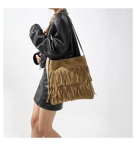 Close-up of bohemian large capacity tote bag with long tiered fringes in camel brown