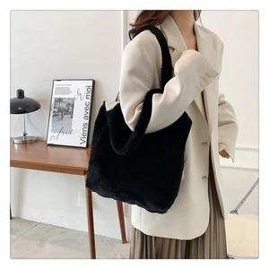 Detail of high-density black plush faux fur tote bag styled with a professional suit