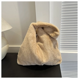 Nahaufnahme der weichen Kunstfellstruktur einer hellbraunen minimalistischen Bucket-Bag