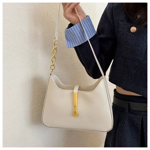 Détail du sac bandoulière en cuir blanc cassé avec boucle dorée et bandoulière chaîne