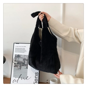 Detail of a soft black faux fur tote bag with plush texture and matching handle