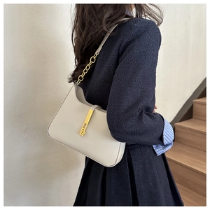 Vue détaillée du sac demi-lune en cuir crème avec bandoulière et boucles dorées