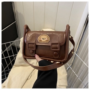 Gros plan du mini sac bandoulière rétro en similicuir marron avec écusson de chien